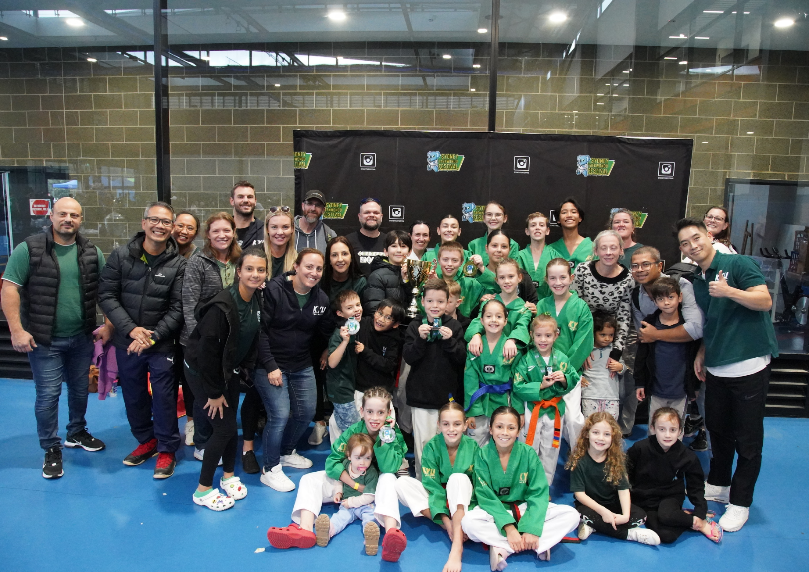 Competition team and families celebrating tournament success together